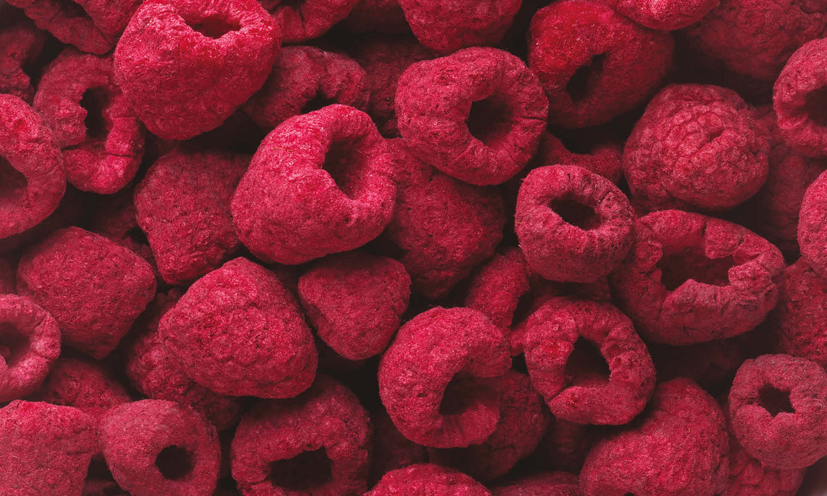 Anhäufung ganzer gefriergetrockneter Himbeeren in sattem rosa