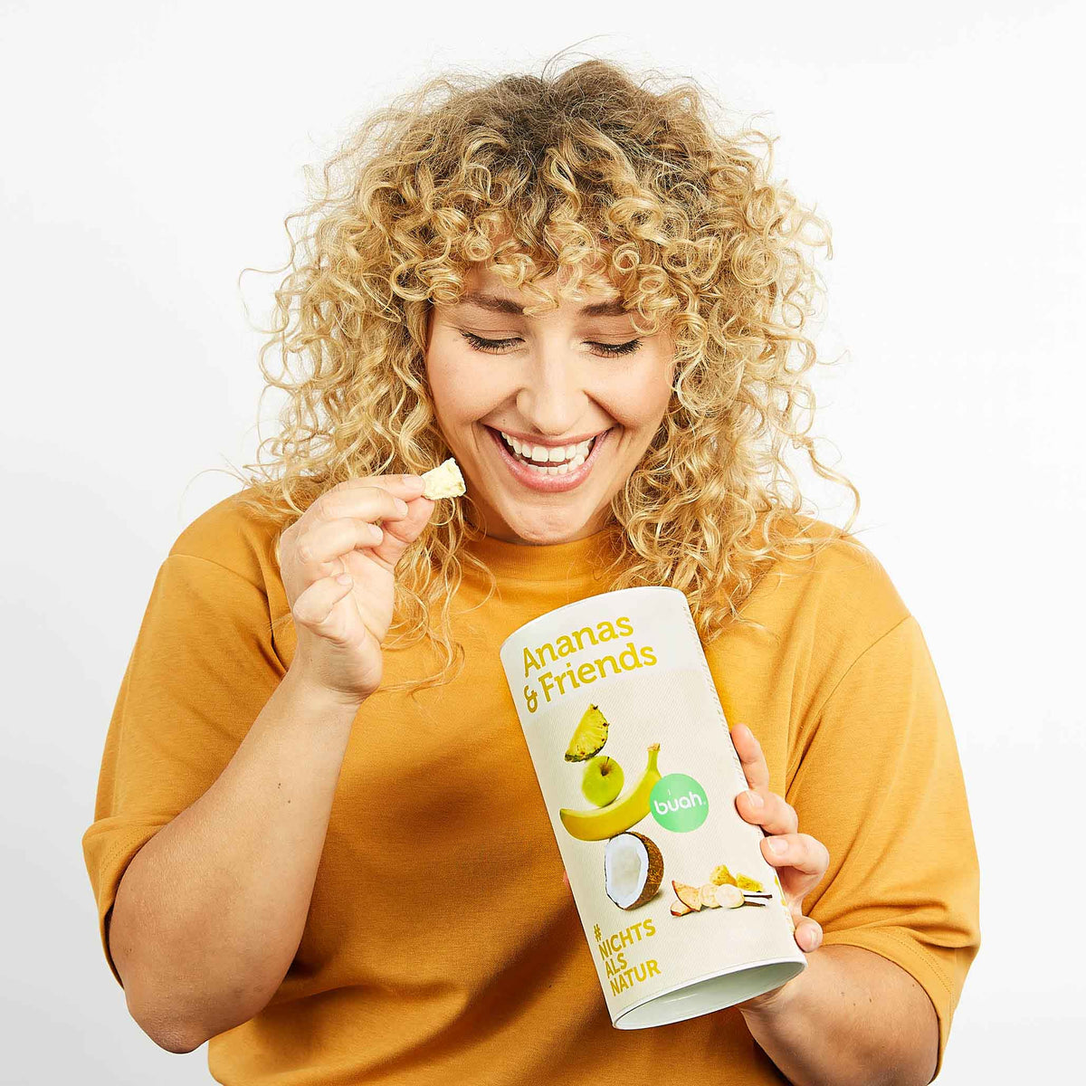 Junge Frau mit blonden Locken und buah Dose Ananas & Friends nimmt Ananas aus der Dose