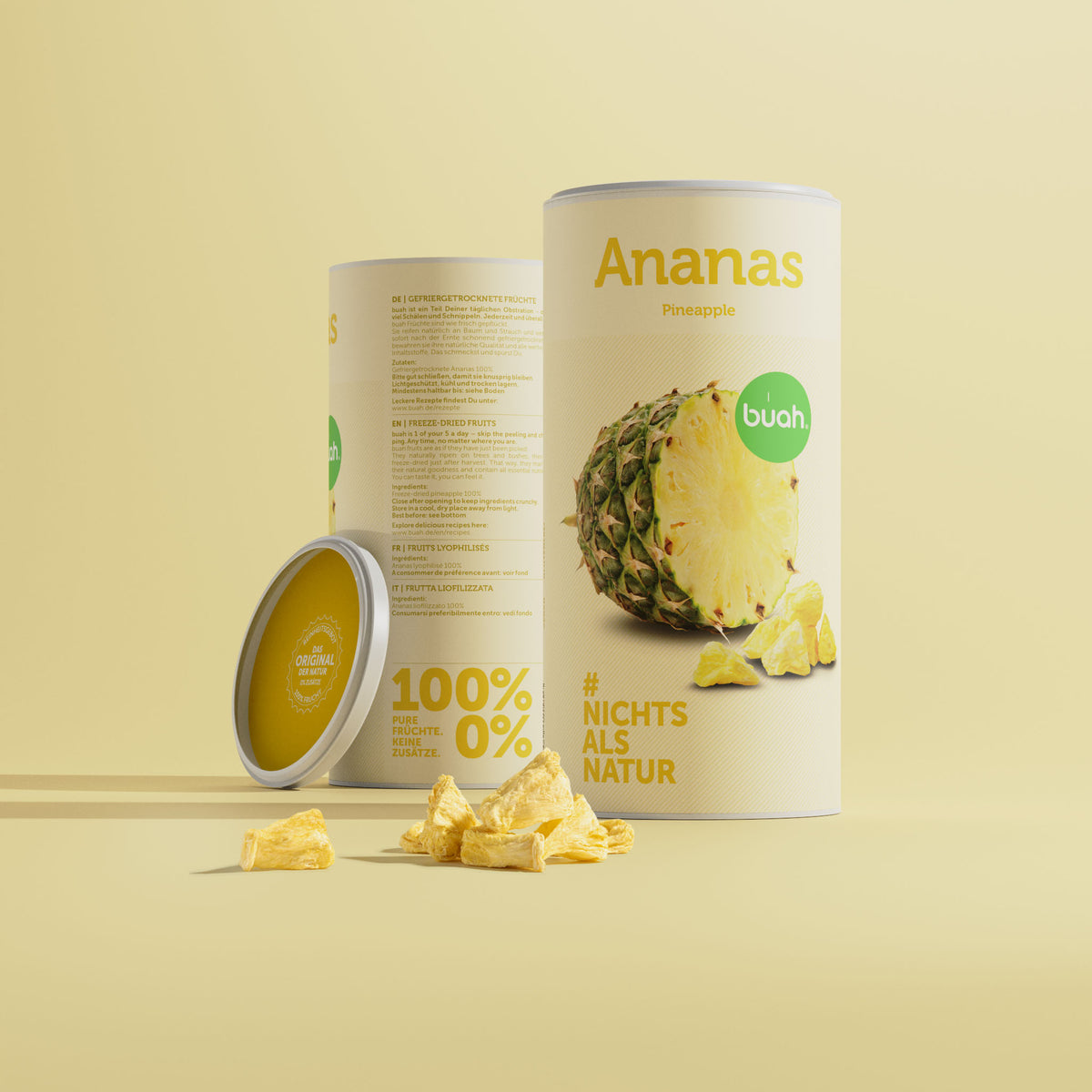 Zwei Dosen buah Ananas nebeneinander mit einem kleinen Haufen gefriergetrockneter Ananas im Vordergrund