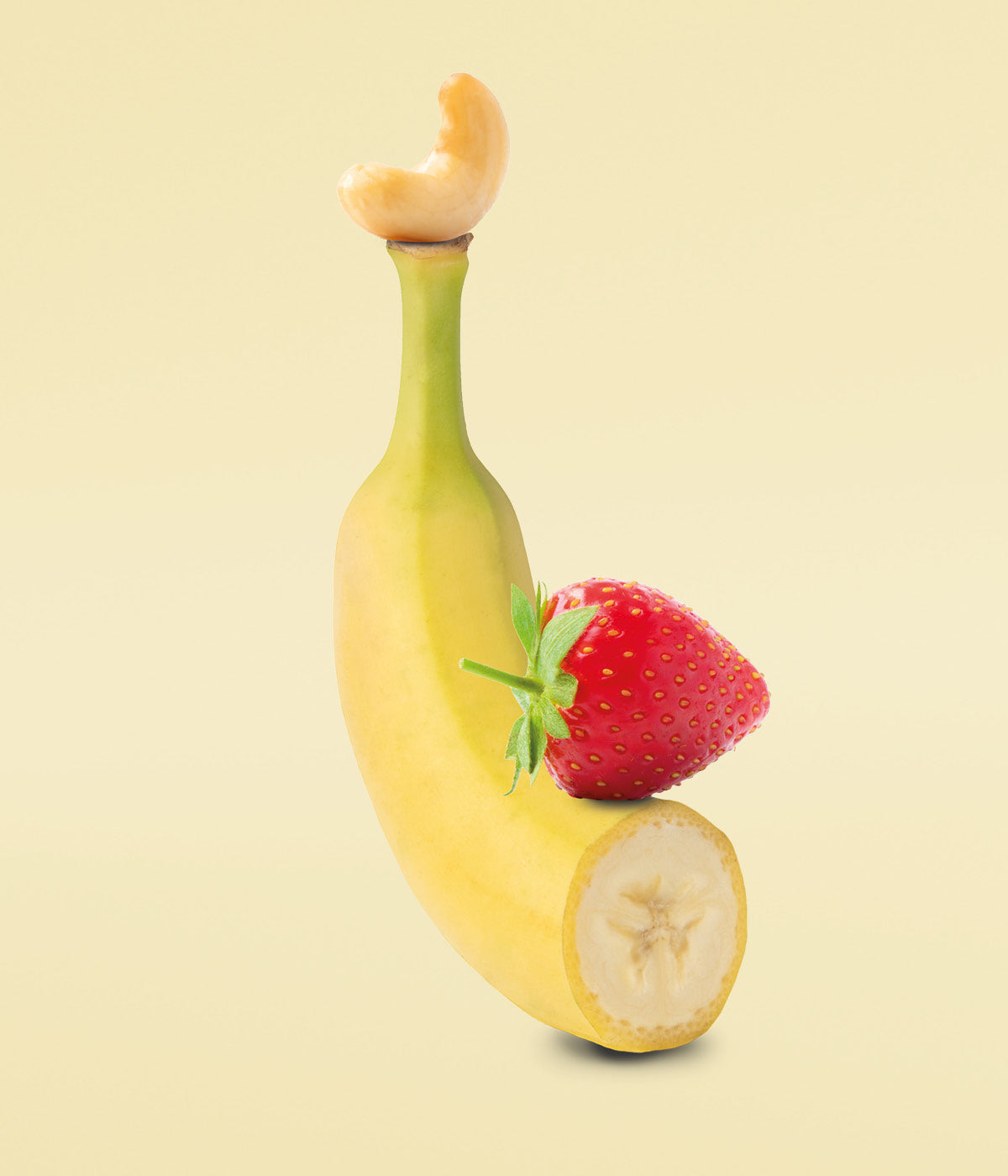 Frische rote Erdbeere liegt auf einer frischen, halbierten, gelben Banane