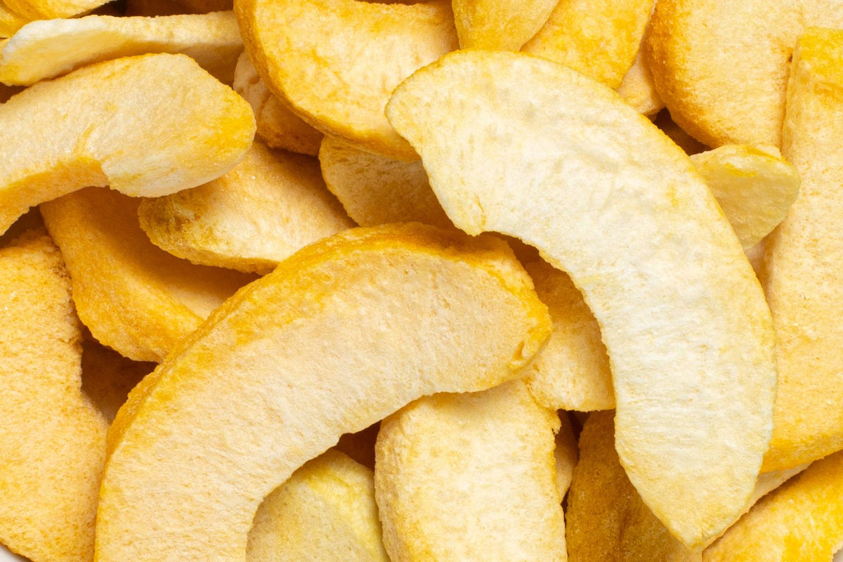 Viele buah gefriergetrockneter Pfirsich Schnitze in hellgelb und dunklerem gelb liegen auf und nebeneinander