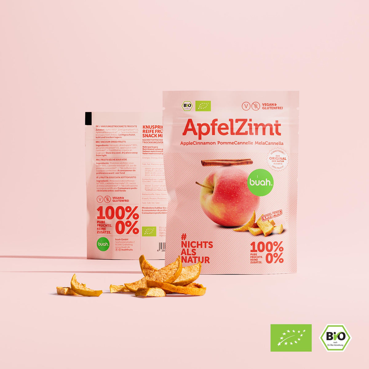 buah ApfelZimt Snackpack Ansicht von Vorne und Hinten, die nebeneinander stehen, kleine Papierpackung, rechteckig, mit der Abbildung eines Apfel, auf dem eine Stange Zimt liegt, rosa Farbtoene